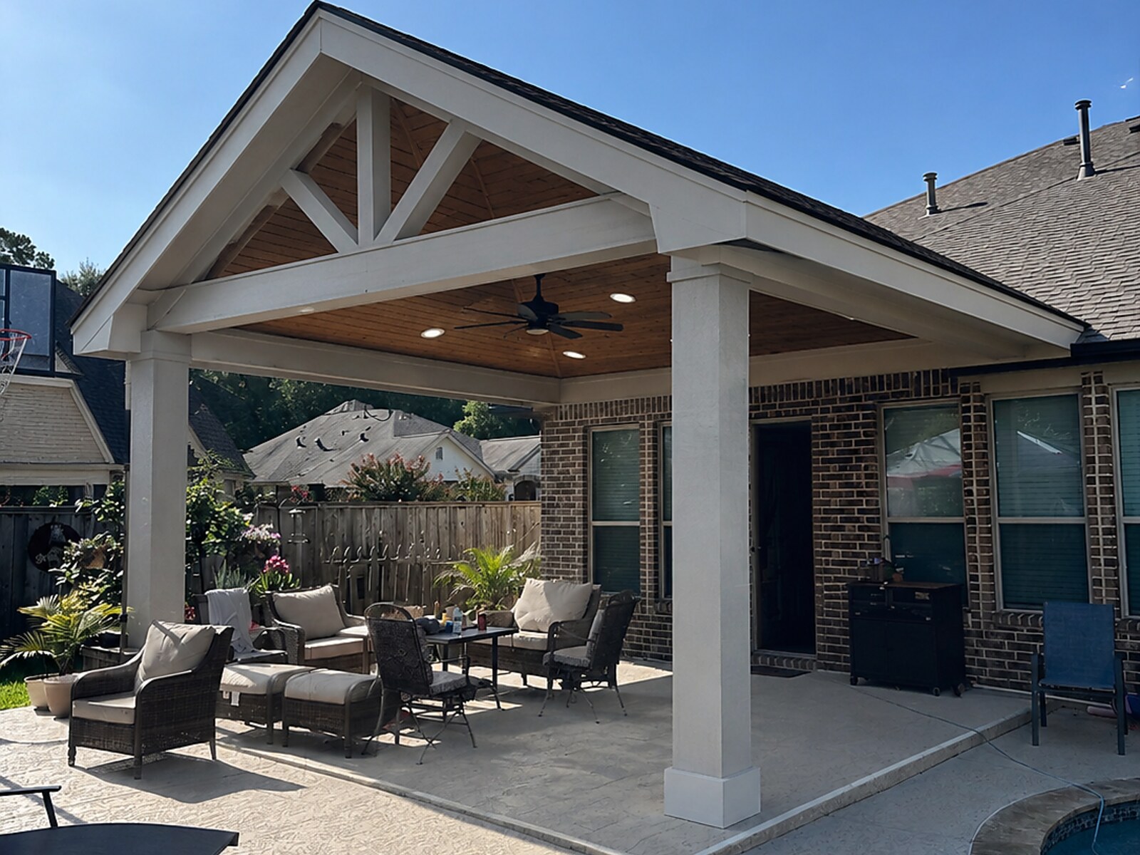 Covered outdoor kitchen and patio with pool and seating area